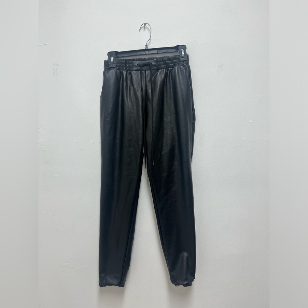 Black leather pants with cuffed bottoms.
